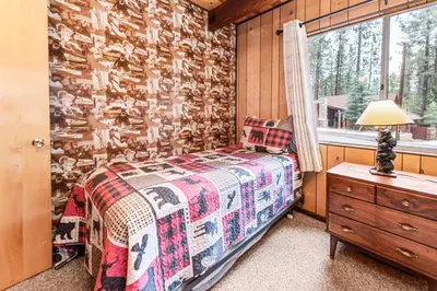 a bedroom with a bed and a window at Bear Crossing - Walk to Snow Summit! Visit this charming mountain home compete with foosball table in Big Bear Lake