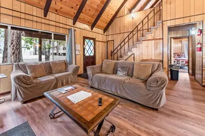 a living room with a couch and a table at Bear Crossing - Walk to Snow Summit! Visit this charming mountain home compete with foosball table in Big Bear Lake
