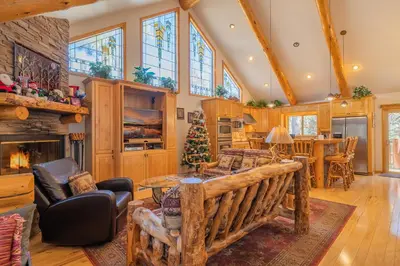 a living room with a couch and a fireplace at Bearfoot Bungalow - Premium and spacious home close to the National Forest and The Village! in Big Bear Lake