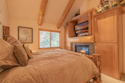 a bedroom with a bed and a fireplace at Bearfoot Bungalow - Premium and spacious home close to the National Forest and The Village! in Big Bear Lake