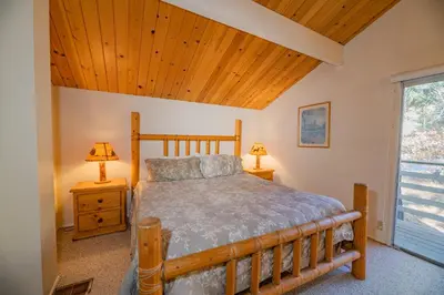 a bedroom with a bed and a wooden ceiling at Best View - Spacious home with game room, and 180 degree panoramic view of Big Bear Lake! in Fawnskin