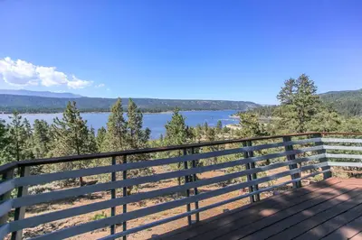 a balcony with a view of a lake at Best View - Spacious home with game room, and 180 degree panoramic view of Big Bear Lake! in Fawnskin