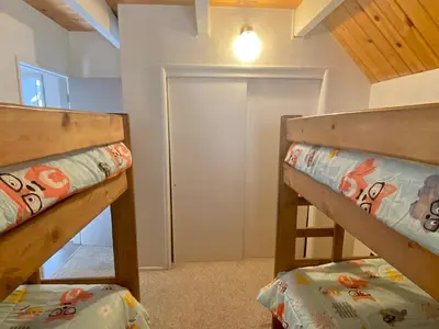 two bunk beds in a room with a closet at Best View - Spacious home with game room, and 180 degree panoramic view of Big Bear Lake! in Fawnskin