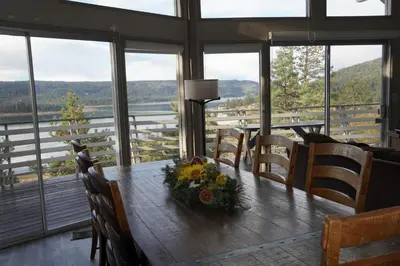 a dining room with a table with flowers on it at Best View - Spacious home with game room, and 180 degree panoramic view of Big Bear Lake! in Fawnskin