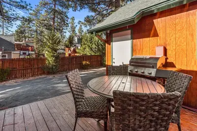 a patio with a table and chairs and a grill at Blue Jay Chalet - Classic mountain cabin in one of Big Bear's quietest neighborhoods! in Big Bear Lake