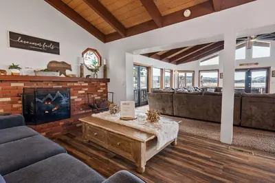 a living room with couches and a fireplace at Grand Lakefront Escape - Gorgeous Lakefront home with Hot Tub and Game Room! in Big Bear Lake