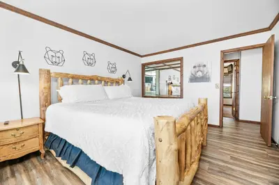 a bedroom with a large bed and a mirror at Grand Lakefront Escape - Gorgeous Lakefront home with Hot Tub and Game Room! in Big Bear Lake