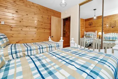 two beds in a room with wooden walls at Hidden Spot - Desirable Fox Farm area of Big Bear in Big Bear Lake