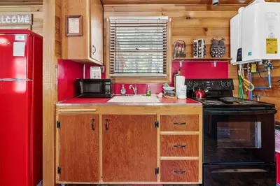 a kitchen with a sink and a red refrigerator at Highland Hideaway - Walk to lake and village! in Big Bear Lake