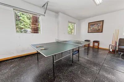 a ping pong table in the middle of a room at Kubo Del Sol - DREAM LOCATION WITH HOT TUB! Beautiful, light and bright log cabin! in Big Bear Lake