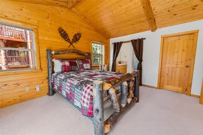 a bedroom with a bed in a log cabin at Kubo Del Sol - DREAM LOCATION WITH HOT TUB! Beautiful, light and bright log cabin! in Big Bear Lake