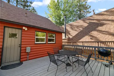 a patio with a table and chairs on a deck at Lake Cottage - Vintage Big Bear Cabin close to The Village and Lake in Big Bear Lake