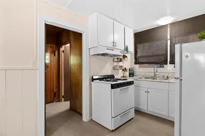 a white kitchen with a stove and a refrigerator at Lake Cottage - Vintage Big Bear Cabin close to The Village and Lake in Big Bear Lake