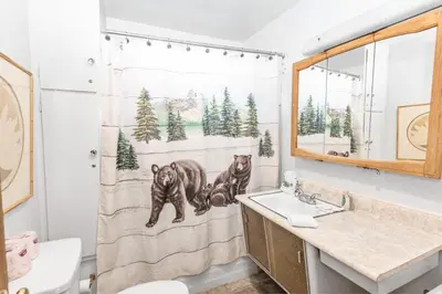 a bathroom with a shower curtain with two bears at Lakefront Retreat - Lakefront cabin near Holloways Marina in Big Bear Lake