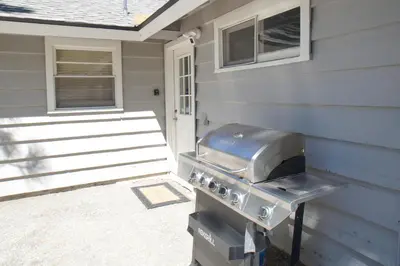 a grill is sitting outside of a house at Lakefront Retreat - Lakefront cabin near Holloways Marina in Big Bear Lake