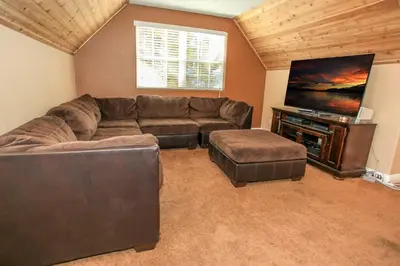 a living room with a couch and a flat screen tv at Lakeview Court Castle - Short walk to the Village and lake in Big Bear Lake