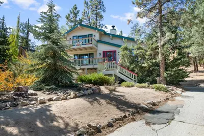 a house in the woods with a lot of trees at Lakeview Haven - Large cabin with game room close to the lake! in Big Bear Lake