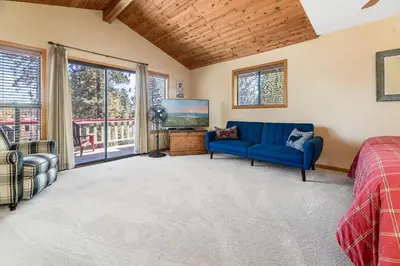 a living room with a blue couch and a tv at Lakeview Haven - Large cabin with game room close to the lake! in Big Bear Lake