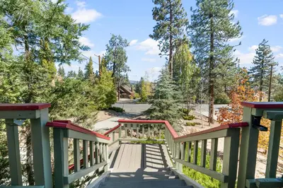 a wooden bridge with trees in the background at Lakeview Haven - Large cabin with game room close to the lake! in Big Bear Lake