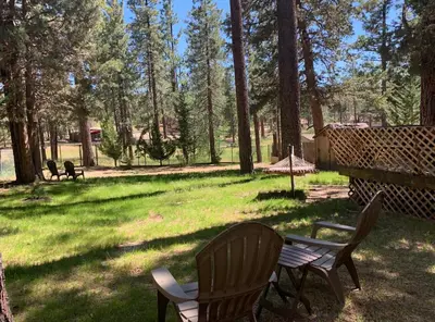 a picnic table and two chairs in a park at Little Big Pine - Perfect, stylish cabin near the lake with a great deck in Big Bear Lake
