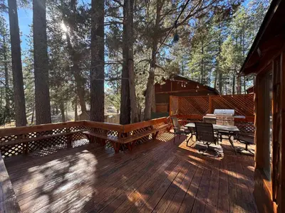 a wooden deck with benches and a picnic table at Little Big Pine - Perfect, stylish cabin near the lake with a great deck in Big Bear Lake