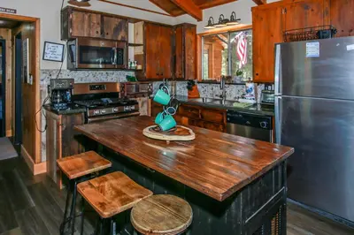 a kitchen with a wooden counter top and a refrigerator at Little Big Pine - Perfect, stylish cabin near the lake with a great deck in Big Bear Lake