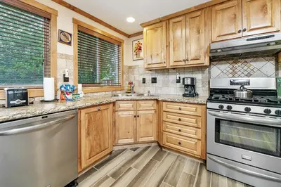 a kitchen with wooden cabinets and stainless steel appliances at Mallard Landing - Steps from the marina and minutes from the Village in Big Bear Lake