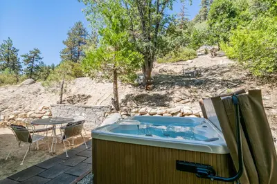a hot tub on a patio with a table at Moonlight Shores Lakefront - Lakefront home with hot tub! in Fawnskin