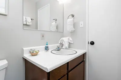 a white bathroom with a sink and a mirror at Moonlight Shores Lakefront - Lakefront home with hot tub! in Fawnskin
