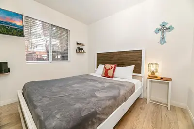 a bedroom with a large bed and a cross on the wall at Nunu's Cabin - Beautiful cabin, close to ski resorts and town, Hot Tub and Board Games! in Big Bear Lake