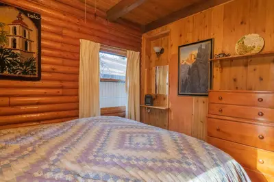 a bedroom with a bed in a log cabin at Rustic Pine - Rustic true log cabin with plenty of charm, Close to everything! in Big Bear Lake