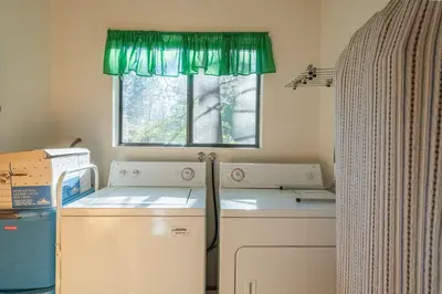 a kitchen with a washing machine and a window at Rustic Pine - Rustic true log cabin with plenty of charm, Close to everything! in Big Bear Lake
