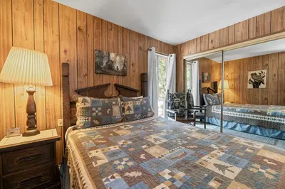 a bedroom with wooden walls and a bed in a room at Sky Krest - Located on a quiet street in the middle of town, Games! Pool table! in Big Bear Lake