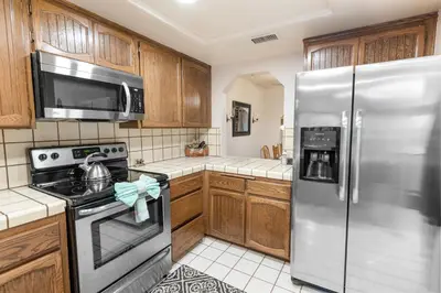 a kitchen with wooden cabinets and a stainless steel refrigerator at Snow Summit Getaway - Walk to Snow Summit Ski Resort in Big Bear Lake