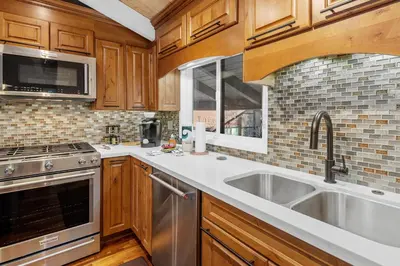 a kitchen with wooden cabinets and a sink and a stove at Snow Summit Thrush8 - Walk to Snow Summit Ski Resort in Big Bear Lake