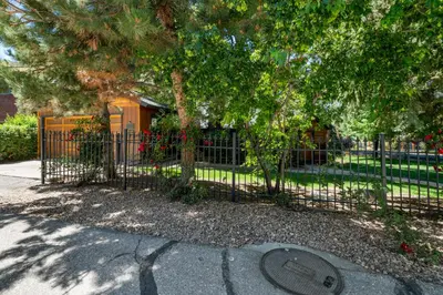 a fence with a tree in front of a park at Stillwater Cove Lakefront - Breathtaking views, charming vintage cabin, woodsy interior! Boat Dock! in Big Bear Lake