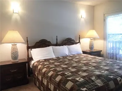 a bedroom with a bed and two lamps on tables at Summit Getaway Condo - Affordable and ideally located, Wood burning fireplace! Walk to Ski Resort in Big Bear Lake