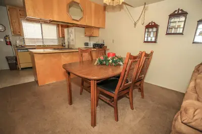 a kitchen with a wooden table with flowers on it at Summit Getaway Condo - Affordable and ideally located, Wood burning fireplace! Walk to Ski Resort in Big Bear Lake
