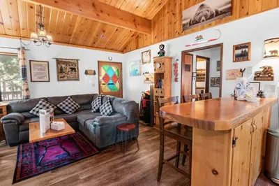 a living room with a couch and a table at The Cuddle Inn - True feeling of a great cabin! Beautiful and homey! Walking distance to the lake! in Big Bear Lake