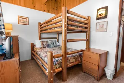 a bedroom with a bunk bed and a dresser at The Cuddle Inn - True feeling of a great cabin! Beautiful and homey! Walking distance to the lake! in Big Bear Lake