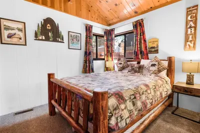 a bedroom with a wooden bed in a room at The Cuddle Inn - True feeling of a great cabin! Beautiful and homey! Walking distance to the lake! in Big Bear Lake
