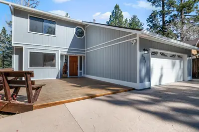 a house with a deck and a garage at Whiskey Pines Chalet - Warm and cozy cabin with modern features made more fun with a gameroom in Big Bear Lake