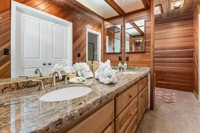 a bathroom with a sink and a mirror at Whiskey Pines Chalet - Warm and cozy cabin with modern features made more fun with a gameroom in Big Bear Lake