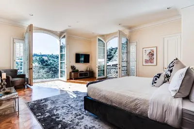 a bedroom with a bed and large windows at Le Jardin in Los Angeles