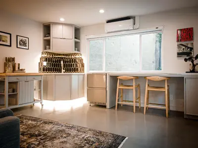 a kitchen with a large window and a counter with stools at The Redline Venice in Los Angeles