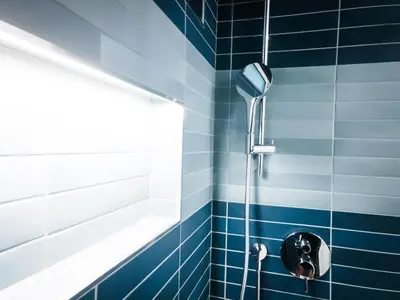 a shower in a blue tiled bathroom at The Redline Venice in Los Angeles