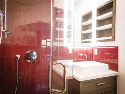 a red tiled bathroom with a shower and a sink at The Redline Venice in Los Angeles