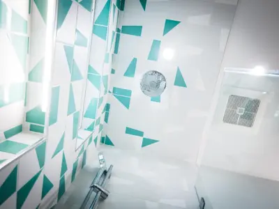 a bathroom with green and white geometric tiles at The Redline Venice in Los Angeles