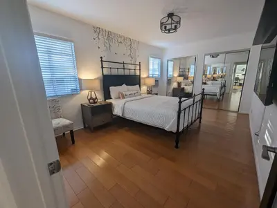 a bedroom with a bed and a chair in it at Stylish 4 Bedroom Home Near Venice Beach with Backyard BBQ in Los Angeles
