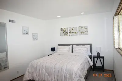 a white bedroom with a bed with white sheets and pillows at Spacious pool home in Pasadena in Pasadena